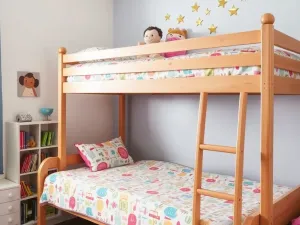 Przytulny salon z szarymi ścianami, białymi meblami i beżowymi zasłonami do podłogi, przepuszczającymi naturalne światło.